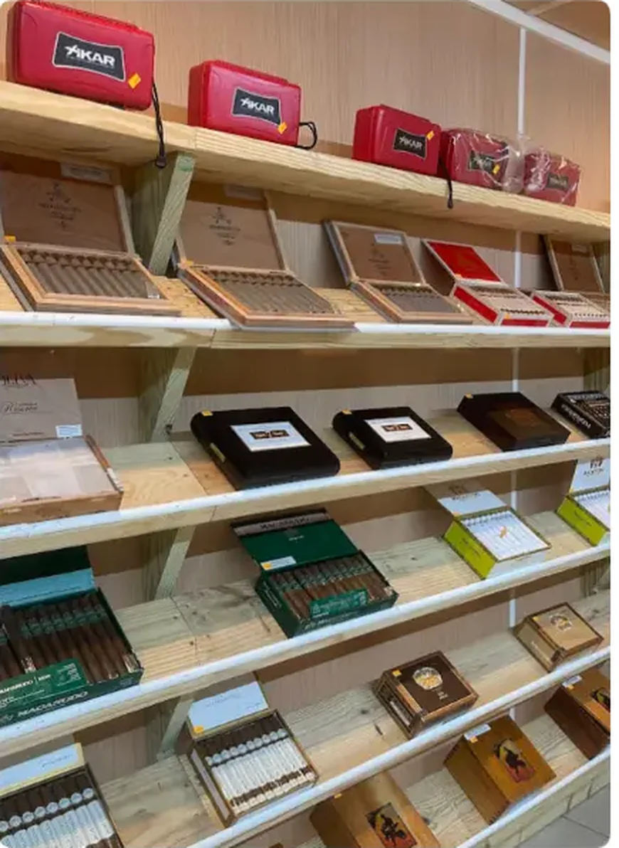 Mega Tobacco Vape & Wireless cigar shelving with open cigar boxes and Xikar travel humidor cases on the top shelf