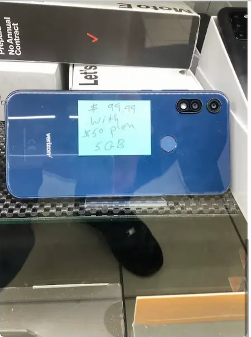 Prepaid smartphone displayed with a handwritten plan card inside the wireless case at Mega Tobacco Vape & Wireless
