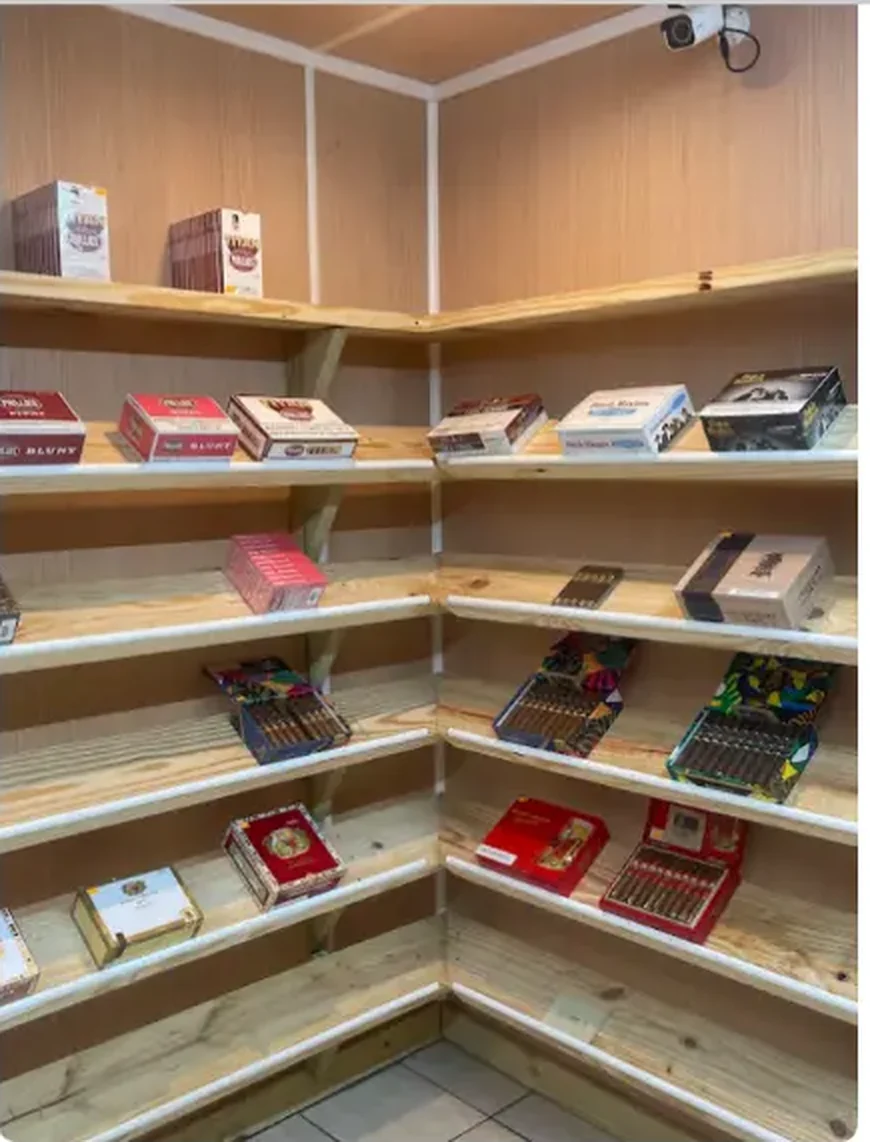 Mega Tobacco Vape & Wireless wooden corner cigar room shelving stacked with open cigar and blunt boxes